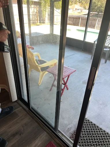 Repaired sliding patio door leading to a screened pool lanai