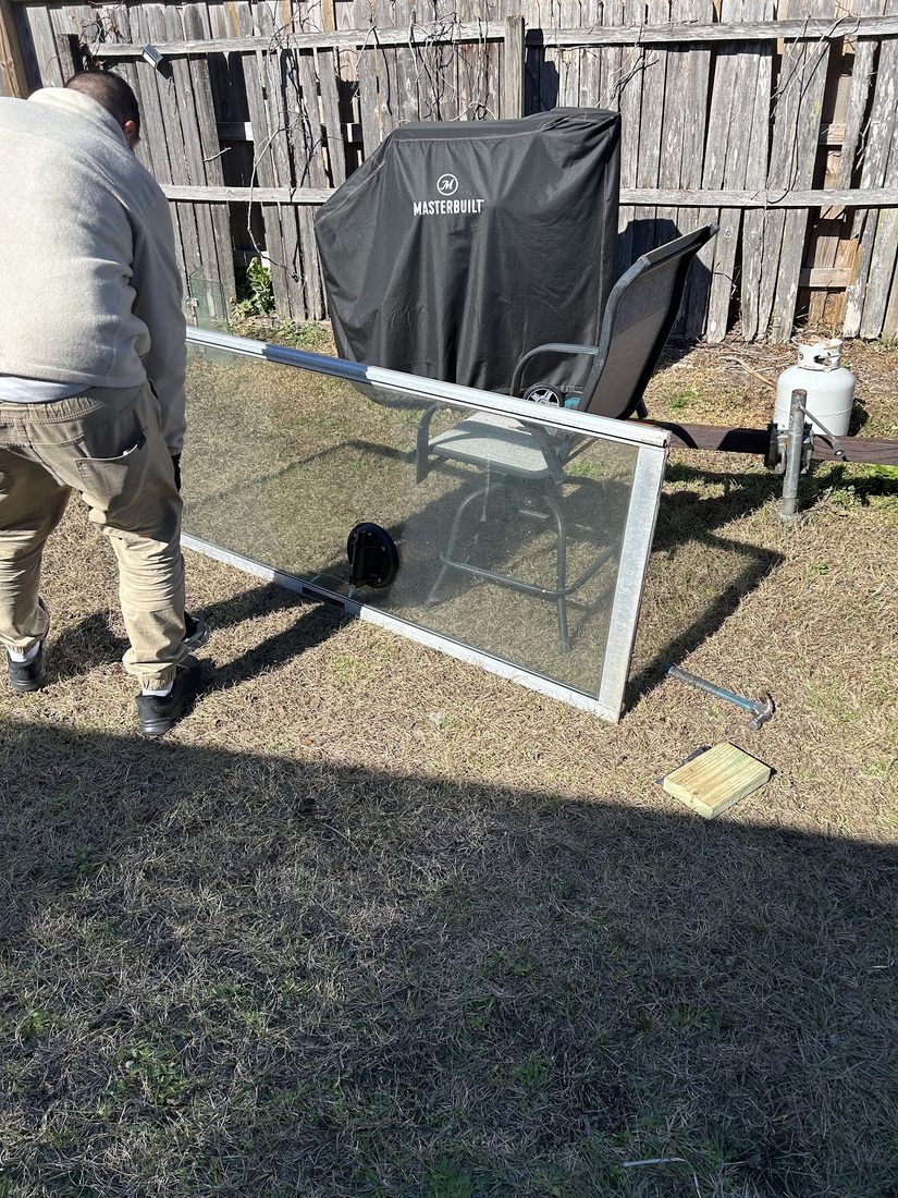 Technician handling a glass panel during sliding door installation