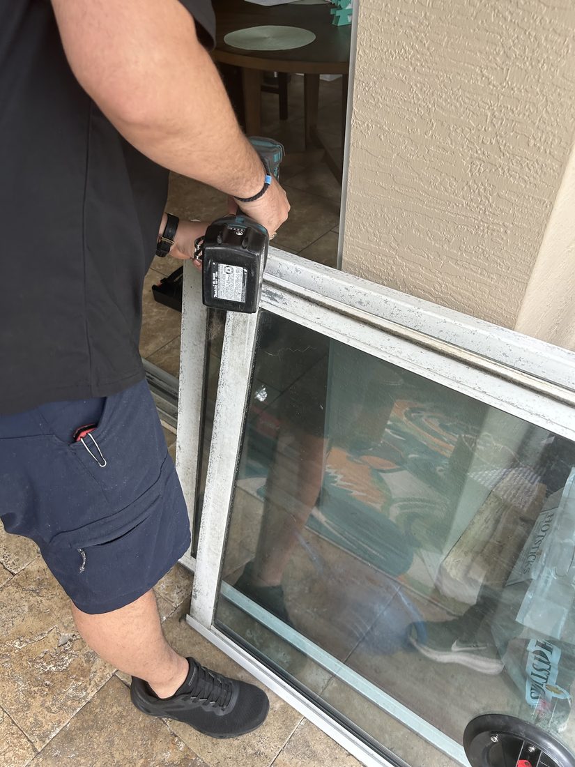Technician repairing a sliding glass door frame on site