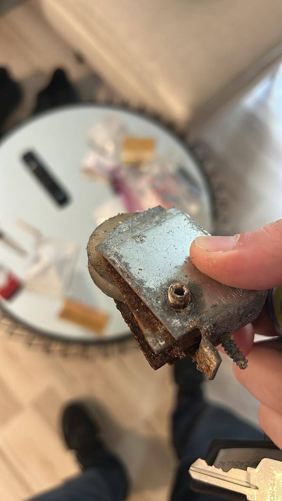 Corroded sliding door roller removed during a repair visit