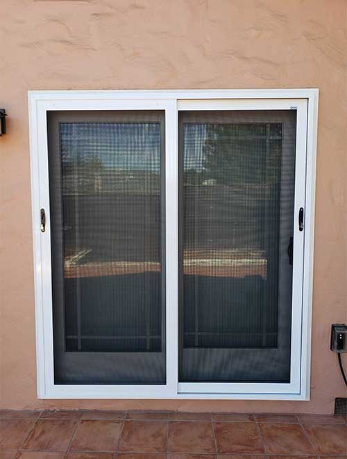 Sliding screen door with double panels in a white frame