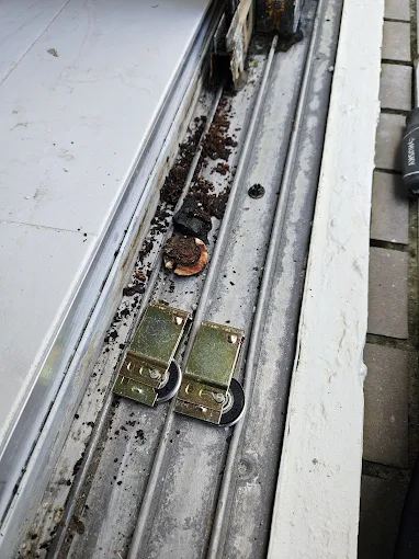 Debris-packed sliding door track before cleaning